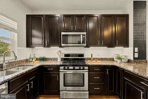 a kitchen with stainless steel appliances granite countertop a refrigerator and a sink