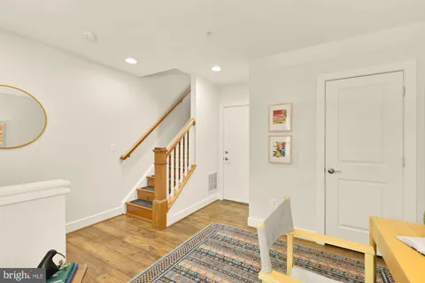 a kitchen with stainless steel appliances granite countertop a stove top oven a sink dishwasher a dining table and chairs with wooden floor