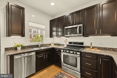 a kitchen with granite countertop stainless steel appliances and cabinets