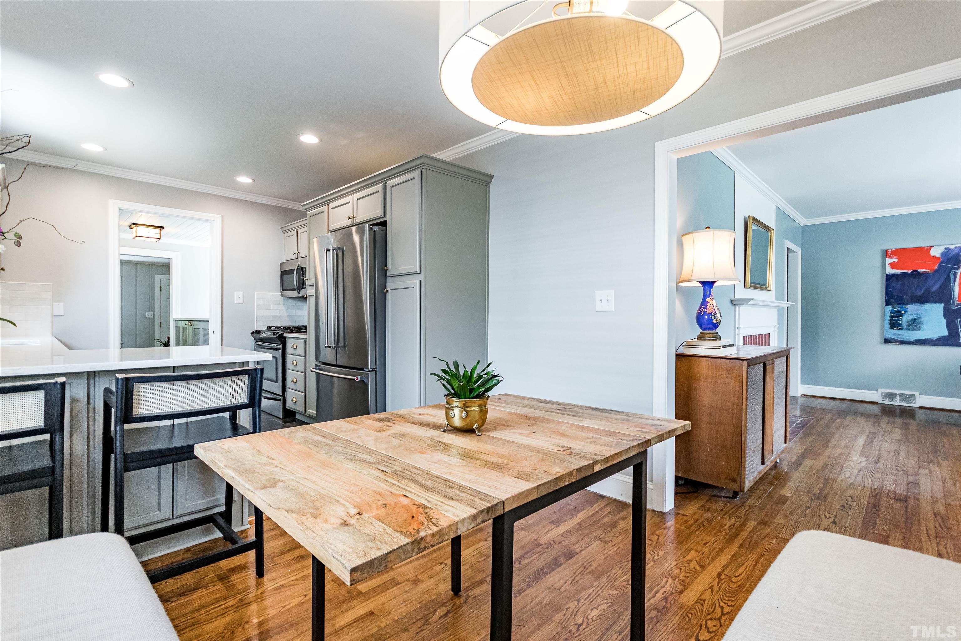 758 East Whitaker Mill Road Raleigh, NC 27608 - Photo 12 of 43 a kitchen with sink refrigerator dining table and chairs