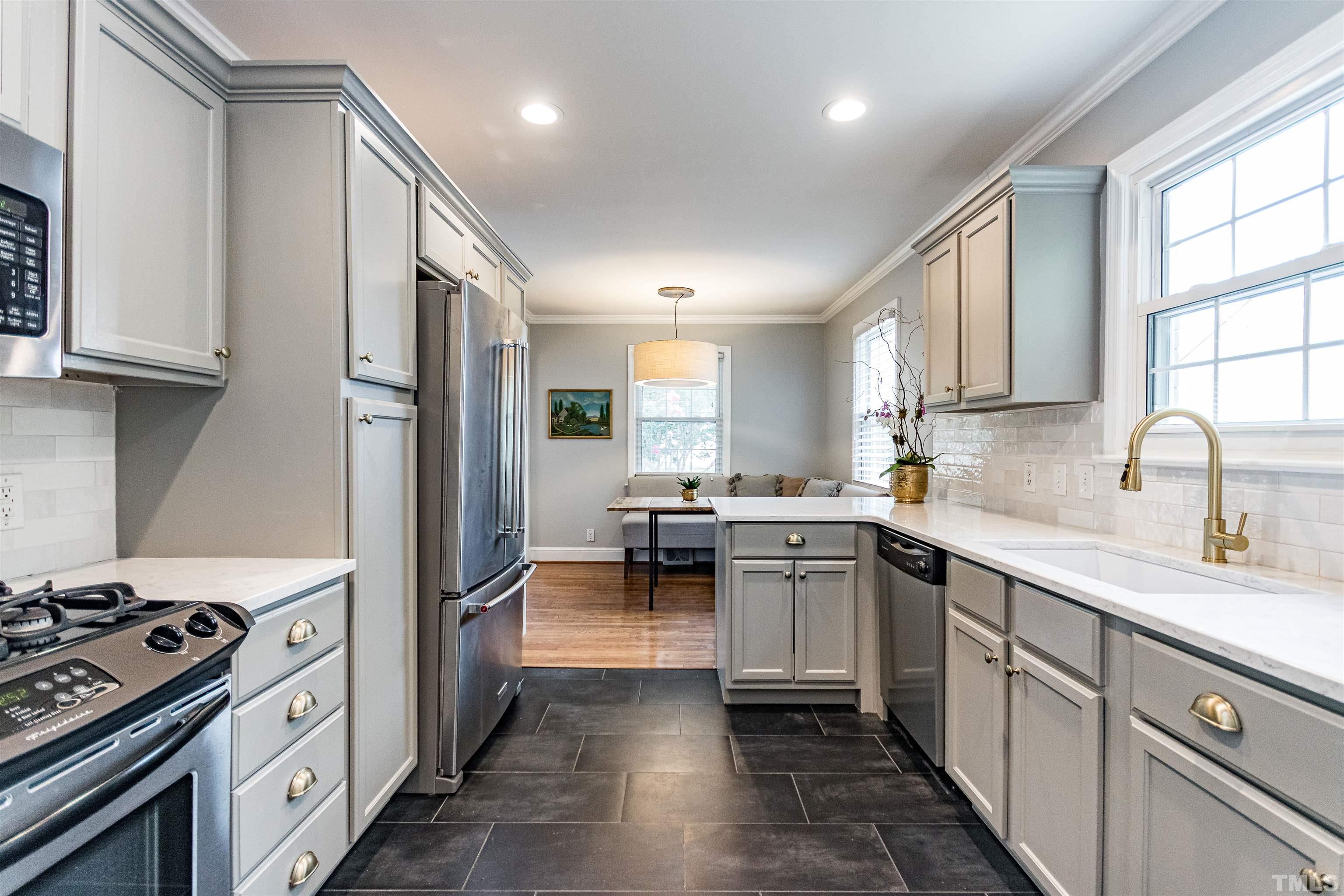 758 East Whitaker Mill Road Raleigh, NC 27608 - Photo 17 of 43 a kitchen with a sink stainless steel appliances and cabinets