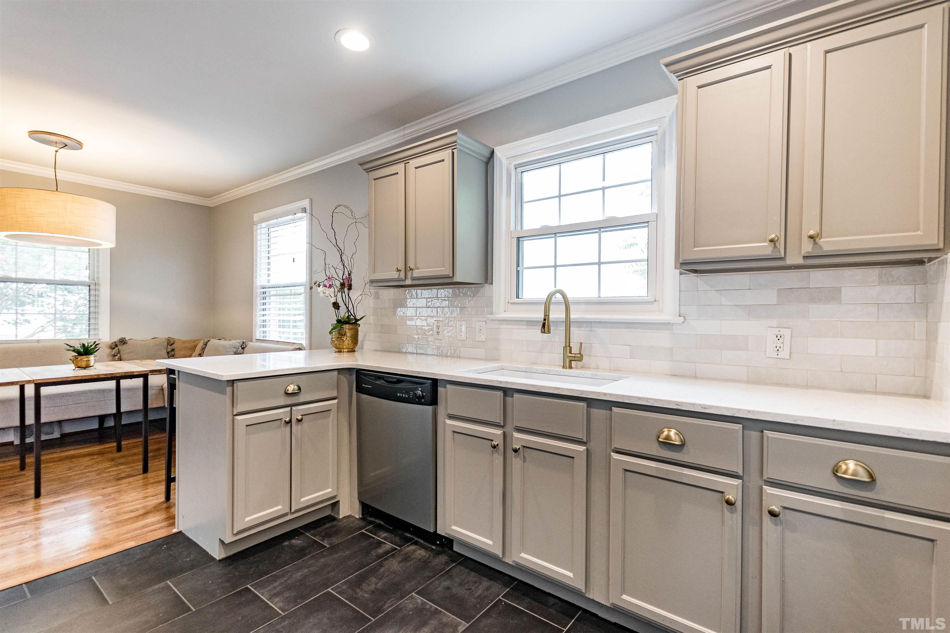 758 East Whitaker Mill Road Raleigh, NC 27608 - Photo 18 of 43 a kitchen with a sink window and cabinets