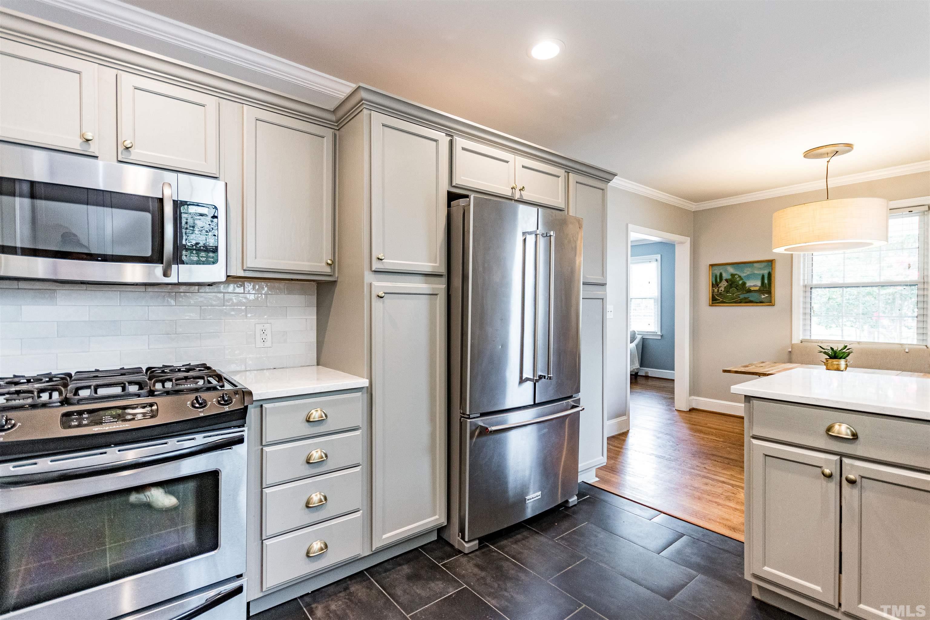 758 East Whitaker Mill Road Raleigh, NC 27608 - Photo 19 of 43 a kitchen with granite countertop a refrigerator stove and microwave