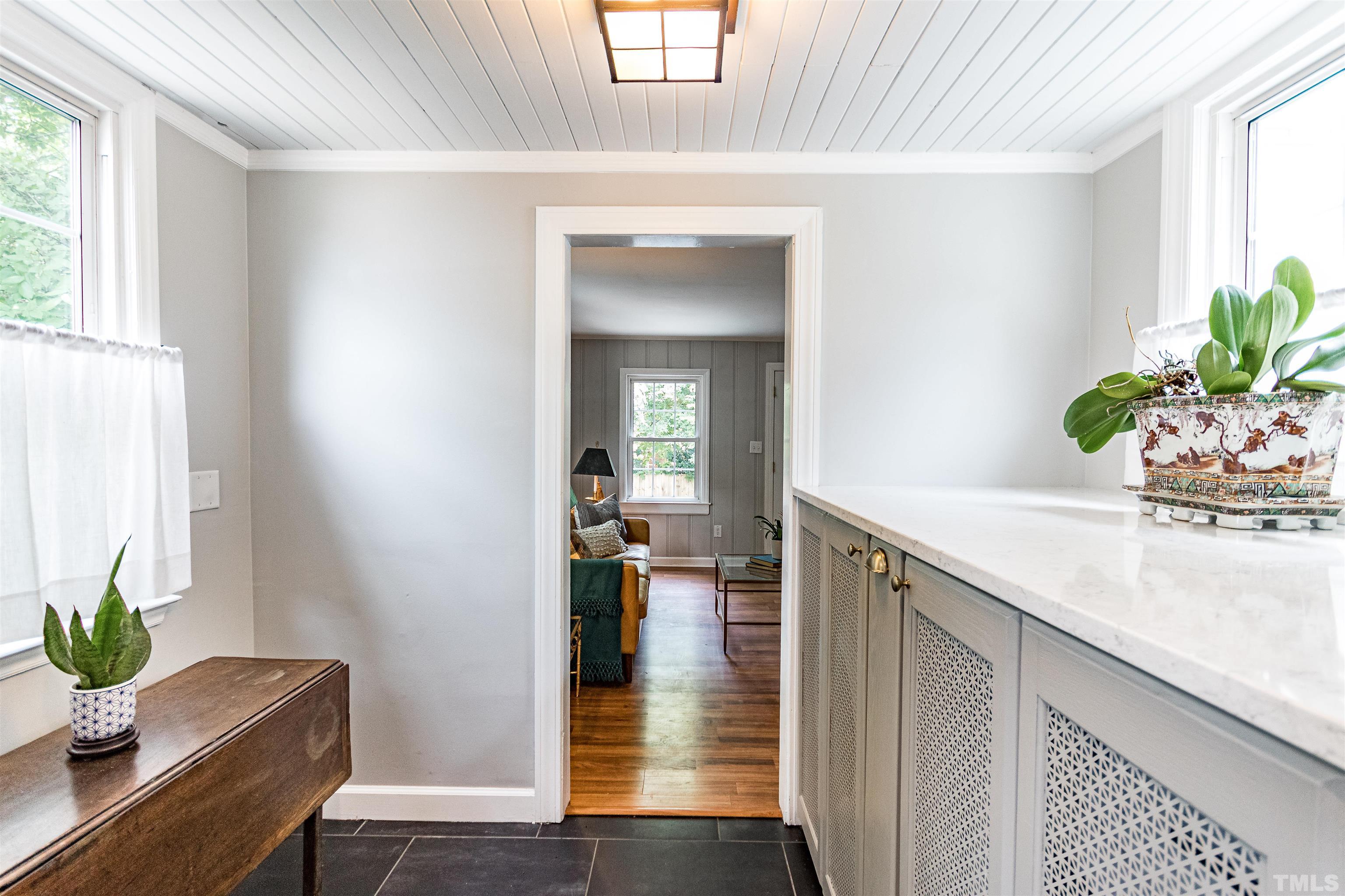 758 East Whitaker Mill Road Raleigh, NC 27608 - Photo 23 of 43 a hallway with wooden floor and a potted plant