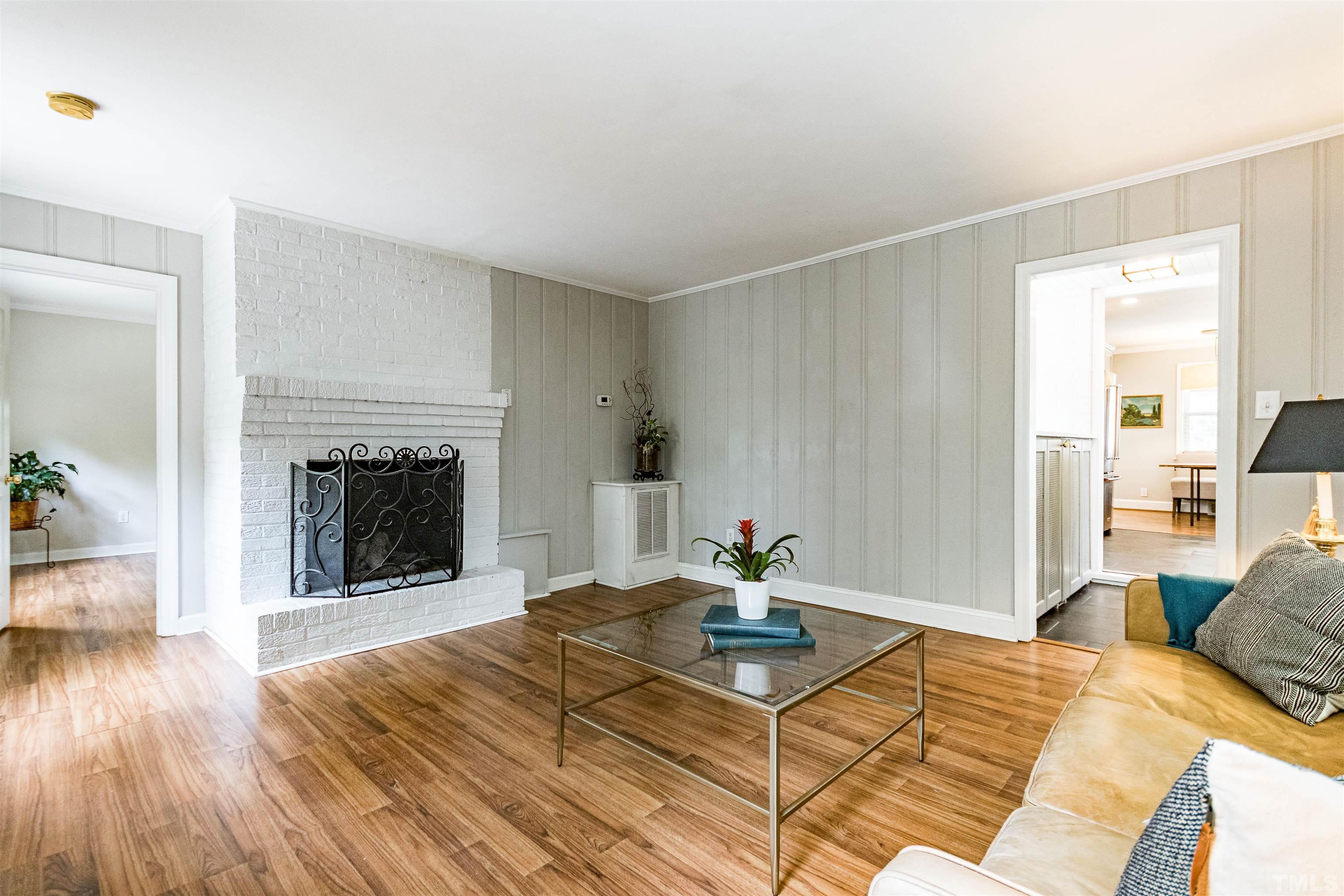758 East Whitaker Mill Road Raleigh, NC 27608 - Photo 24 of 43 a living room with a dining table and a fireplace