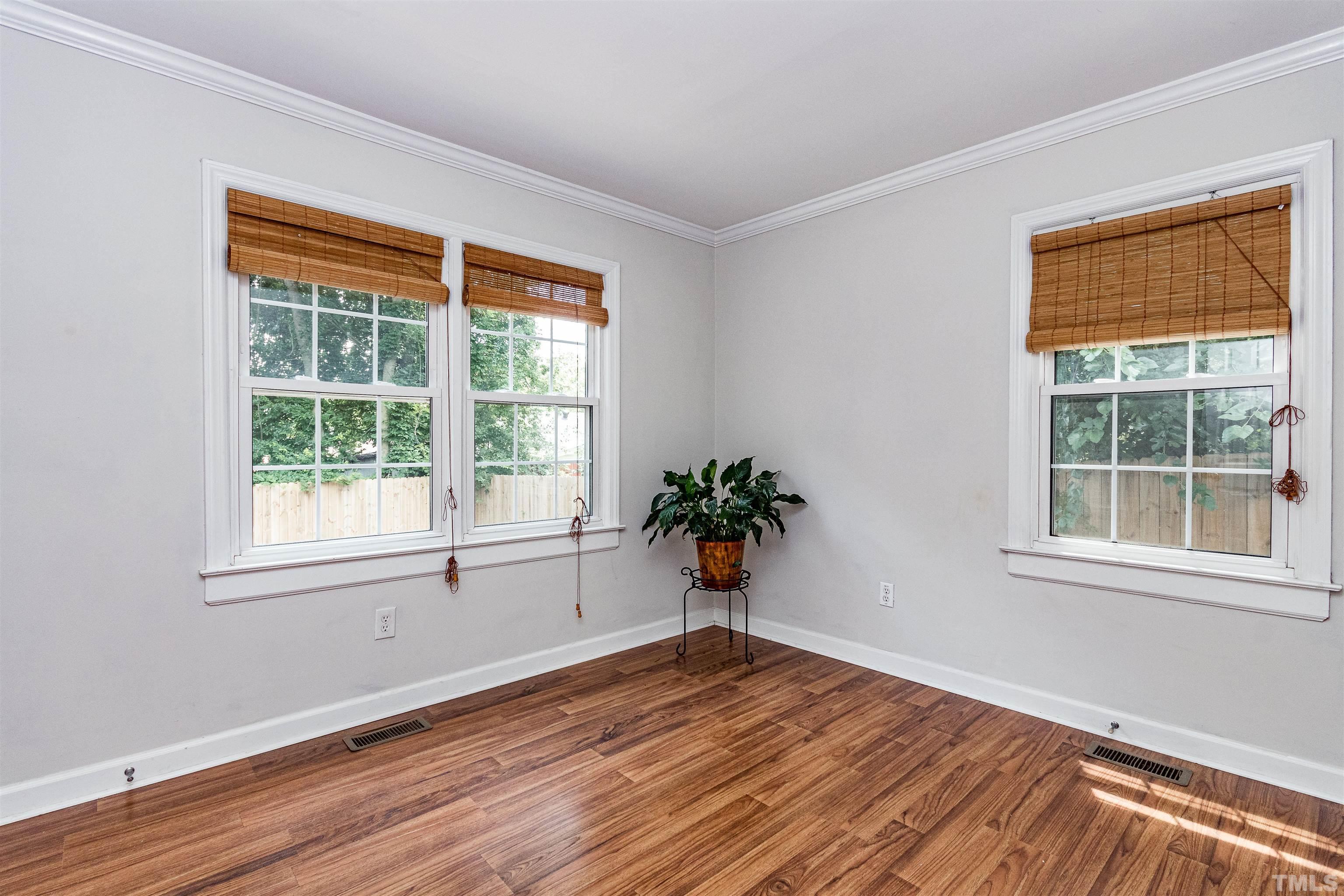 758 East Whitaker Mill Road Raleigh, NC 27608 - Photo 27 of 43 a view of an empty room with wooden floor and a window