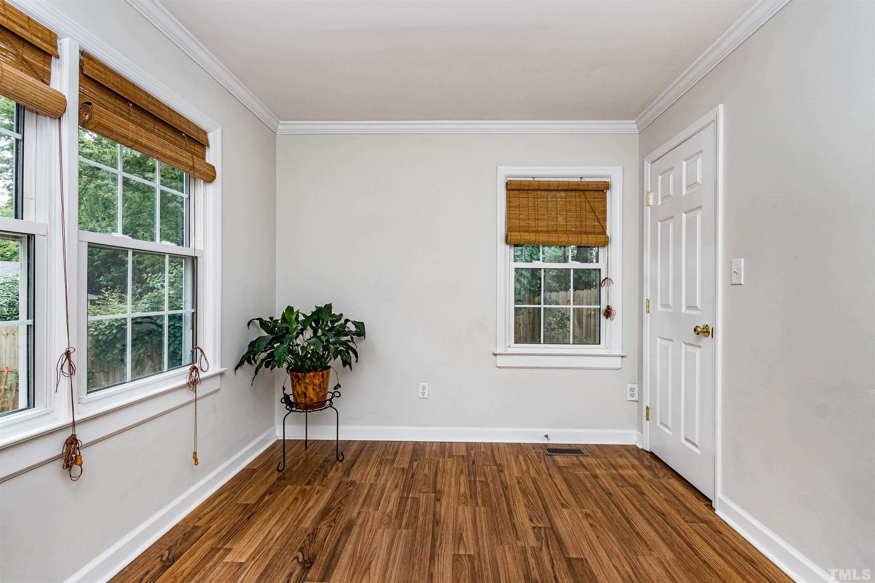 758 East Whitaker Mill Road Raleigh, NC 27608 - Photo 28 of 43 a view of an empty room with wooden floor and a window