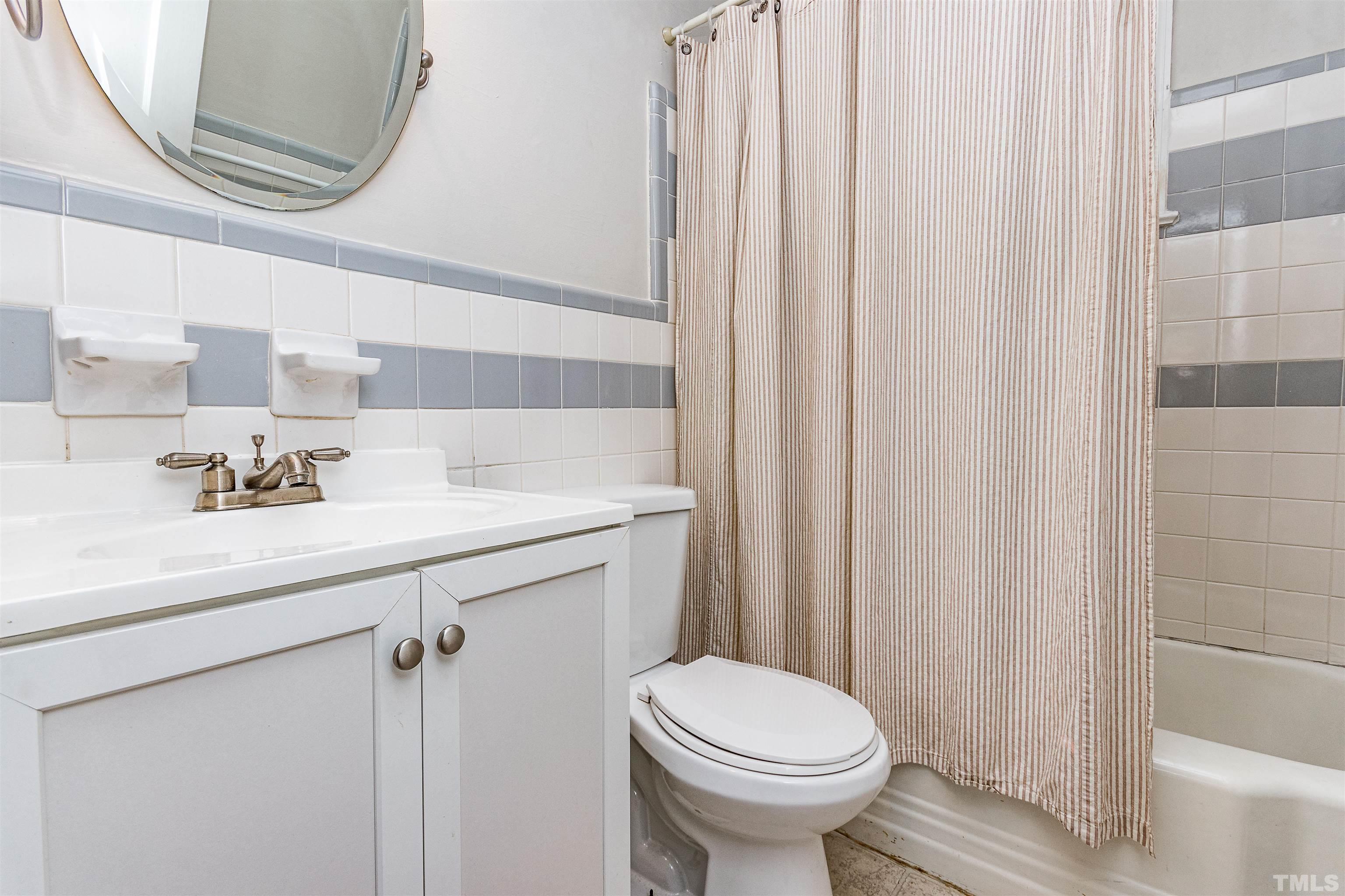 758 East Whitaker Mill Road Raleigh, NC 27608 - Photo 33 of 43 a bathroom with a sink a toilet and shower curtain