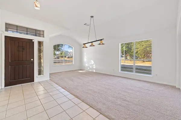 a view of a hallway with wooden floor and a living room