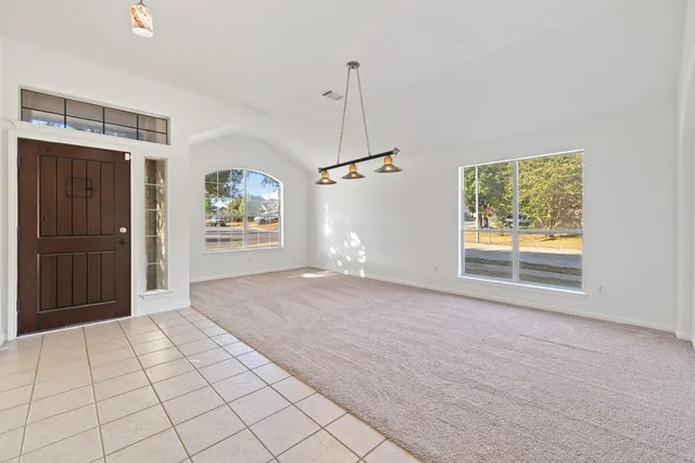 a view of a hallway with wooden floor and a living room