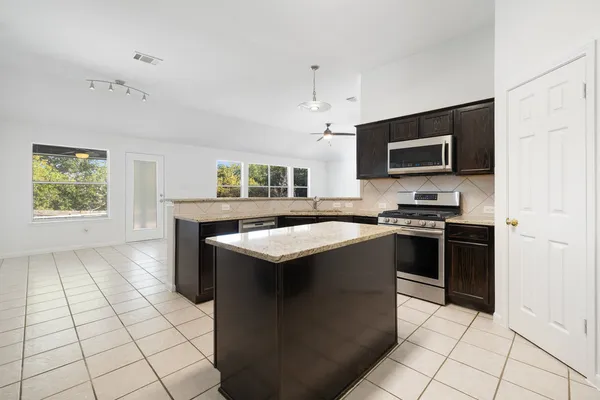 a kitchen with granite countertop a sink and cabinets