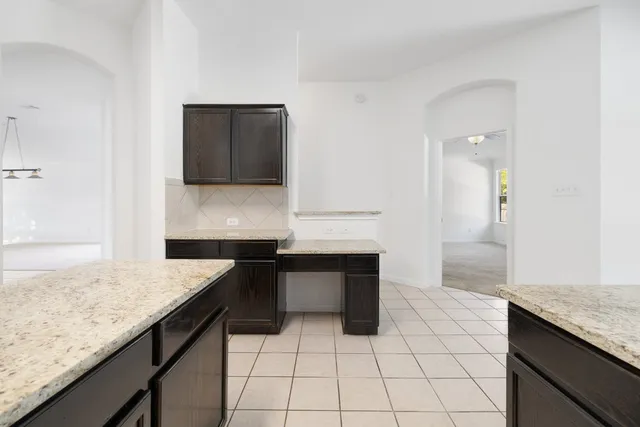 a kitchen with a sink and a stove top oven with wooden floor
