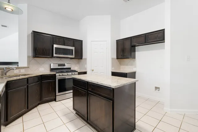 a kitchen with a sink and stainless steel appliances