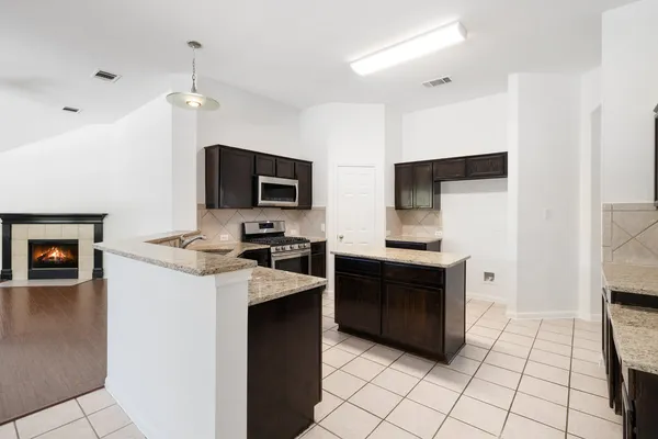 a kitchen with stainless steel appliances a refrigerator sink and microwave