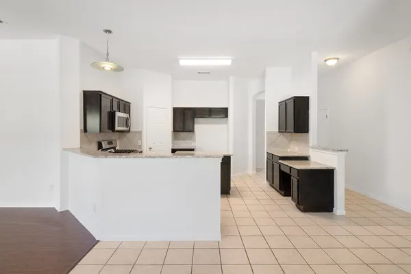 a kitchen with granite countertop white cabinets and stainless steel appliances