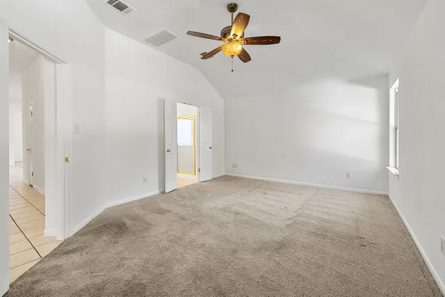 a view of room with a ceiling fan and a window