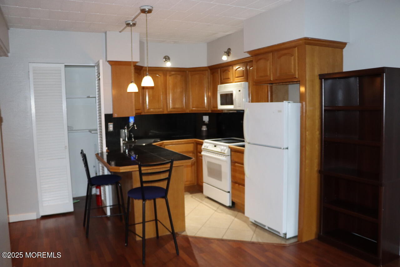 21 Leroy Place, Unit 3F Red Bank, NJ 07701 - Photo 7 of 17 a kitchen with a refrigerator a dining table and chairs