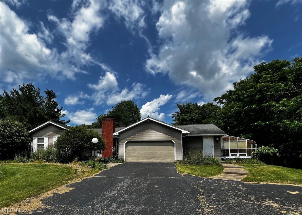 View of front of house with a front lawn and a garage