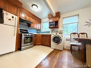 a kitchen with stainless steel appliances granite countertop a refrigerator a stove and a wooden floors