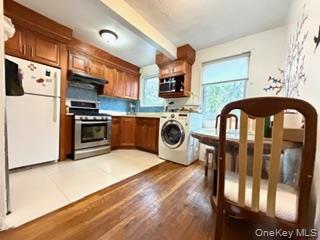 217-11 73rd Avenue, Unit 2 Queens, NY 11364 - Photo 5 of 21 a kitchen with stainless steel appliances granite countertop a stove top oven a sink and a refrigerator