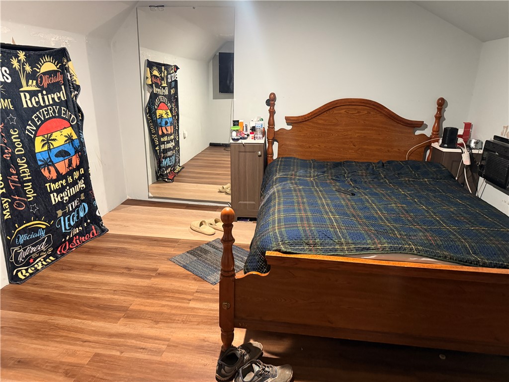 302 Sirrine Street Honea Path, SC 29654 - Photo 22 of 24 Rich hardwood-style flooring extends across this cozy bedroom space, offering a durable and attractive surface.