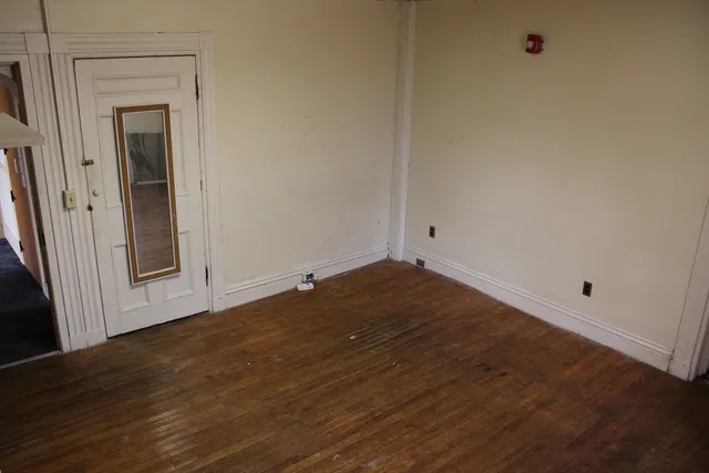 a view of empty room with wooden floor and cabinet