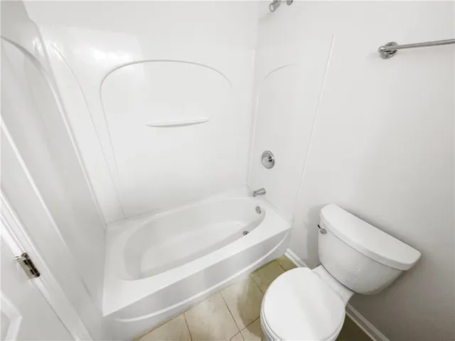 a view of an empty room with wooden floor and a ceiling fan