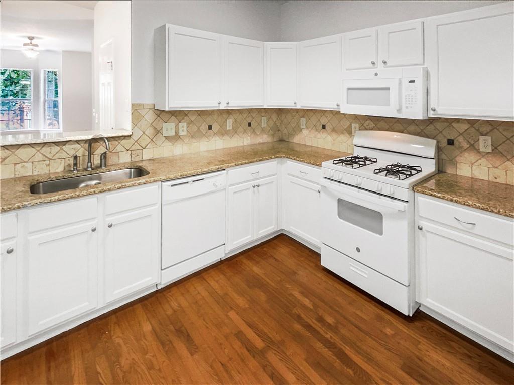 2225 Dillard Crossing Tucker, GA 30084 - Photo 19 of 41 a kitchen with granite countertop white cabinets and white appliances