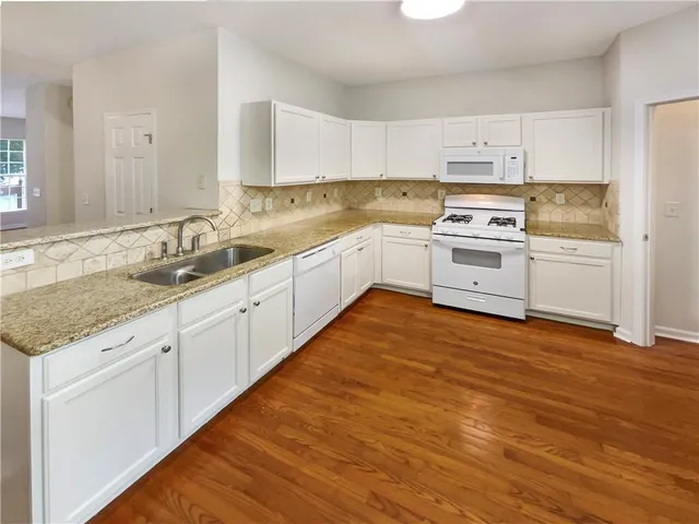 a kitchen with white cabinets and white appliances