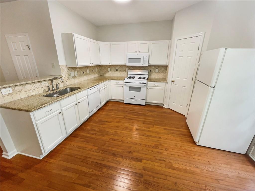 2225 Dillard Crossing Tucker, GA 30084 - Photo 34 of 41 a kitchen with white cabinets and white appliances