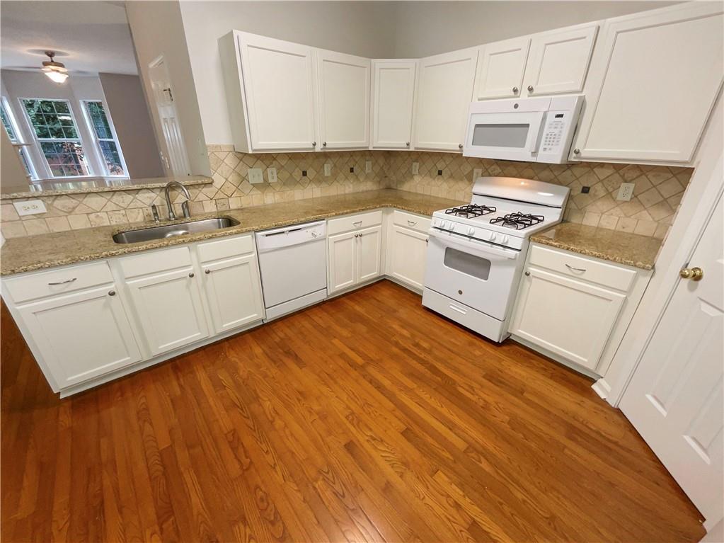 2225 Dillard Crossing Tucker, GA 30084 - Photo 35 of 41 a kitchen with granite countertop white cabinets and white appliances