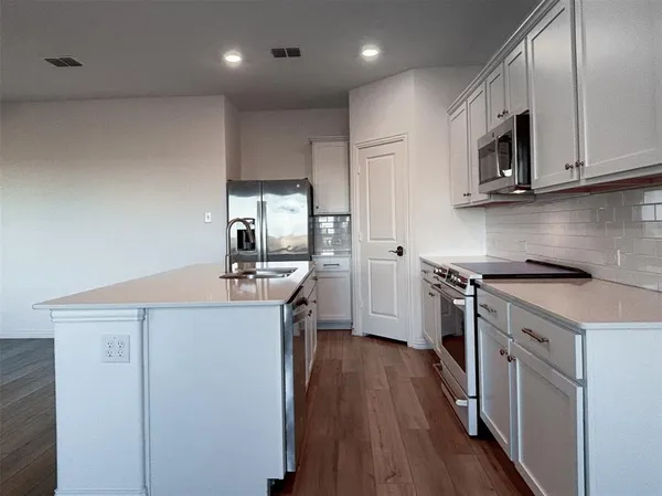 a kitchen with a sink a microwave and cabinets