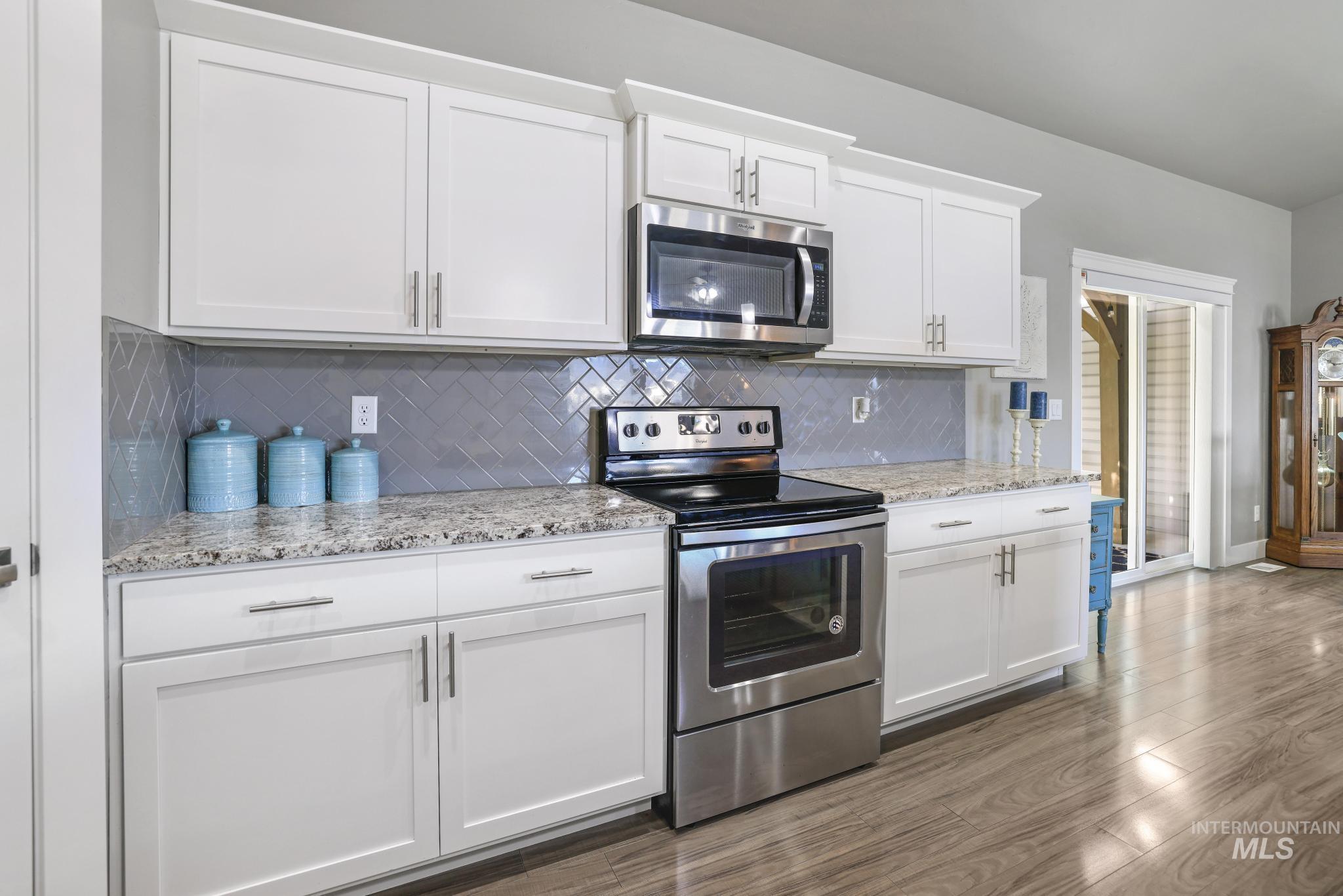 1050 Birchton Loop Twin Falls, ID 83301 - Photo 11 of 45 Kitchen with white shaker-style cabinetry, stainless steel appliances, and wood-finish flooring