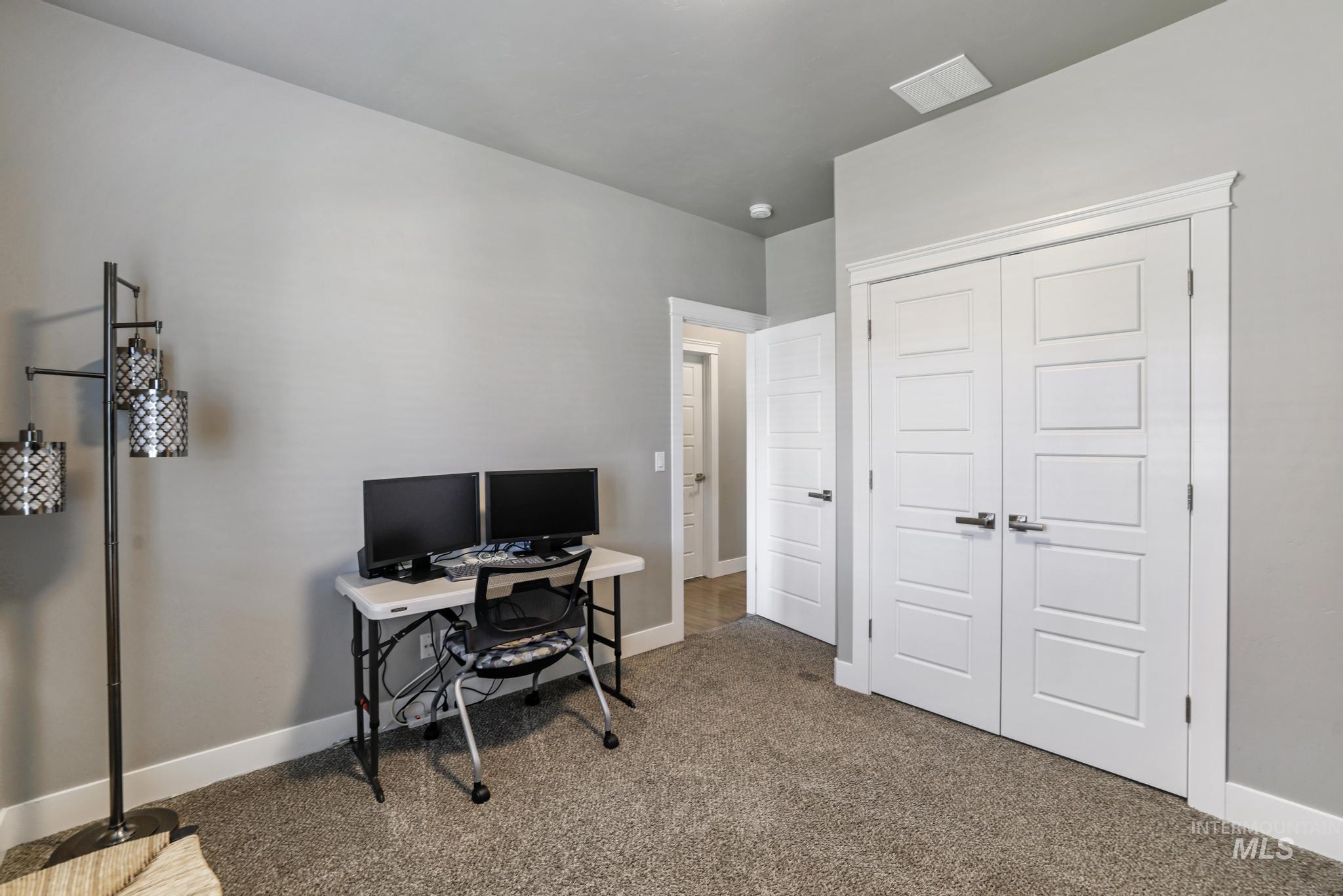 1050 Birchton Loop Twin Falls, ID 83301 - Photo 18 of 45 Interior room featuring neutral wall paint, carpet flooring, white baseboards, and a double-door closet with contemporary hardware and trim