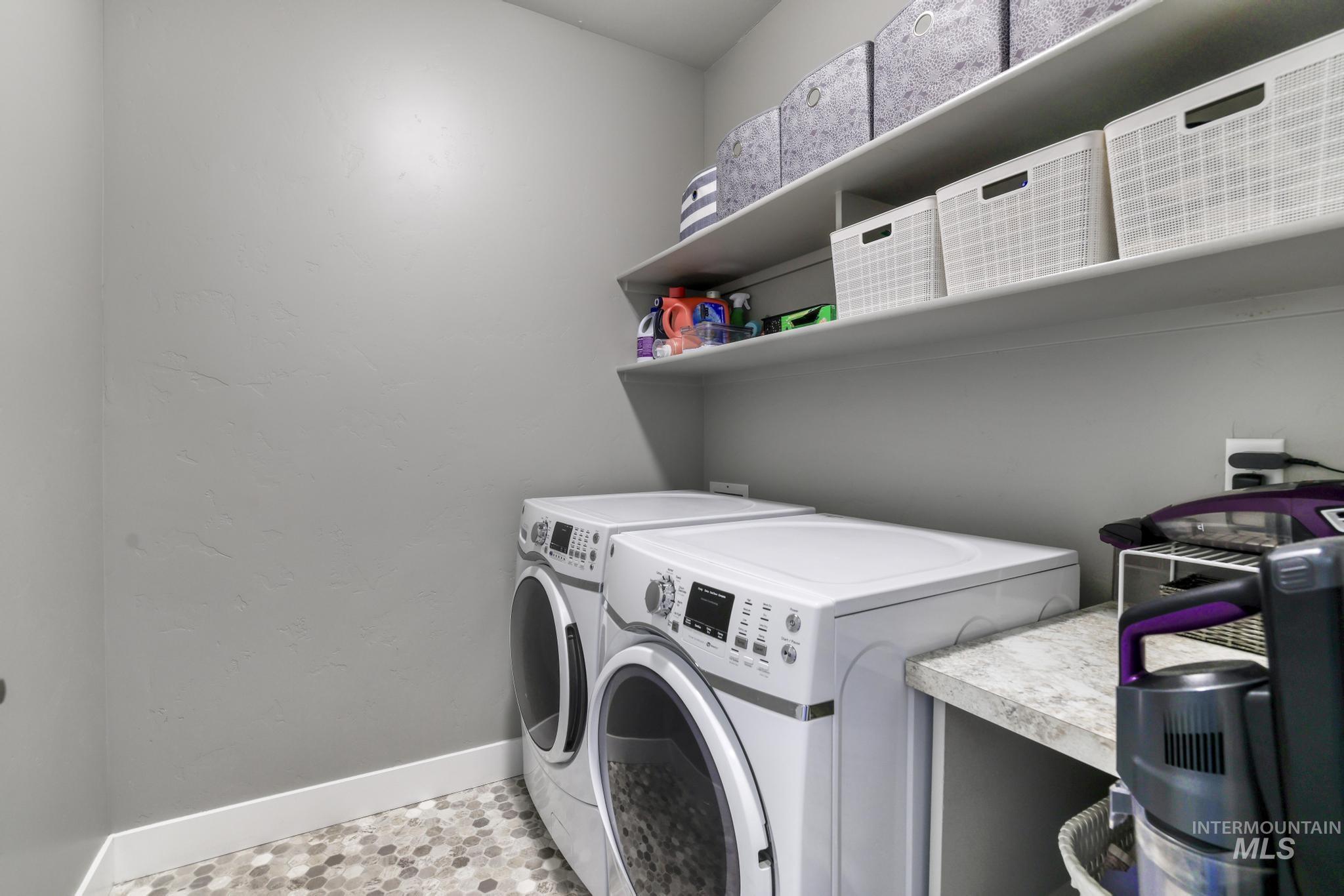 1050 Birchton Loop Twin Falls, ID 83301 - Photo 19 of 45 Dedicated laundry area featuring front-loading appliances, a stone-finish countertop, and integrated shelving