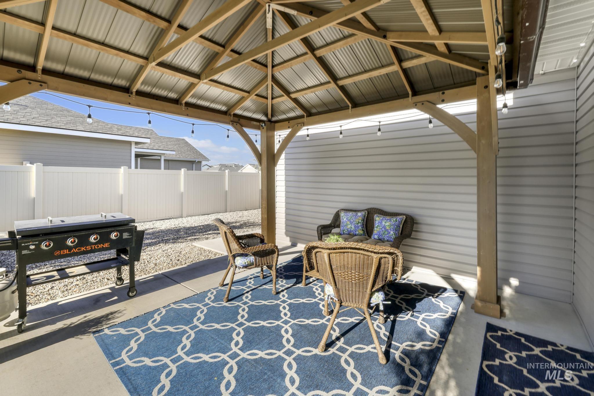 1050 Birchton Loop Twin Falls, ID 83301 - Photo 26 of 45 Outdoor gazebo with a corrugated metal roof, string lighting, and wood-finish posts