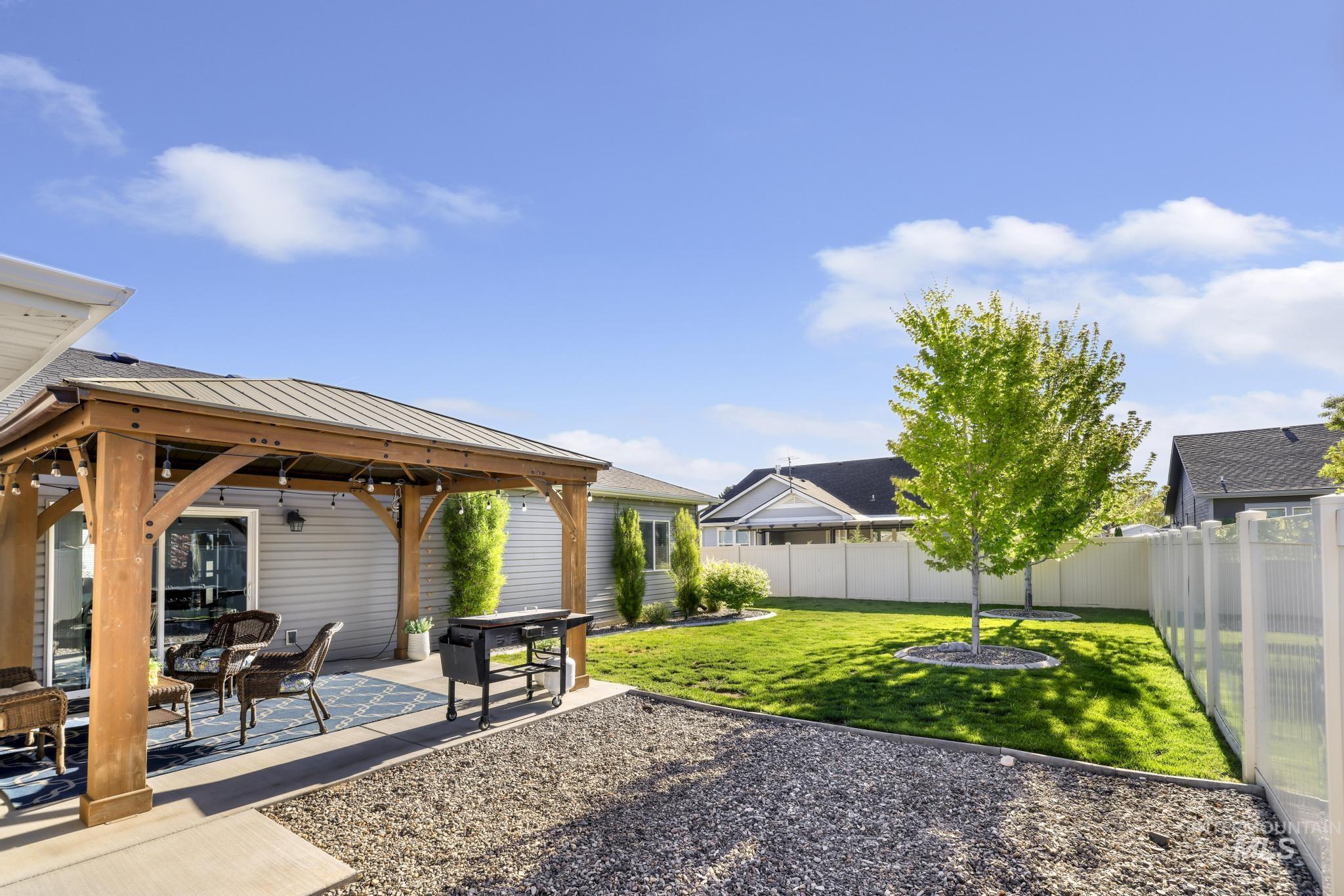 1050 Birchton Loop Twin Falls, ID 83301 - Photo 29 of 45 Expansive backyard featuring a covered patio, gravel hardscaping, and a manicured lawn