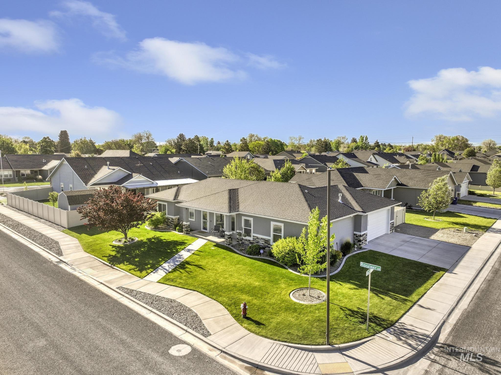 1050 Birchton Loop Twin Falls, ID 83301 - Photo 33 of 45 Corner lot residence featuring a gray exterior, attached garage, and a lush green lawn