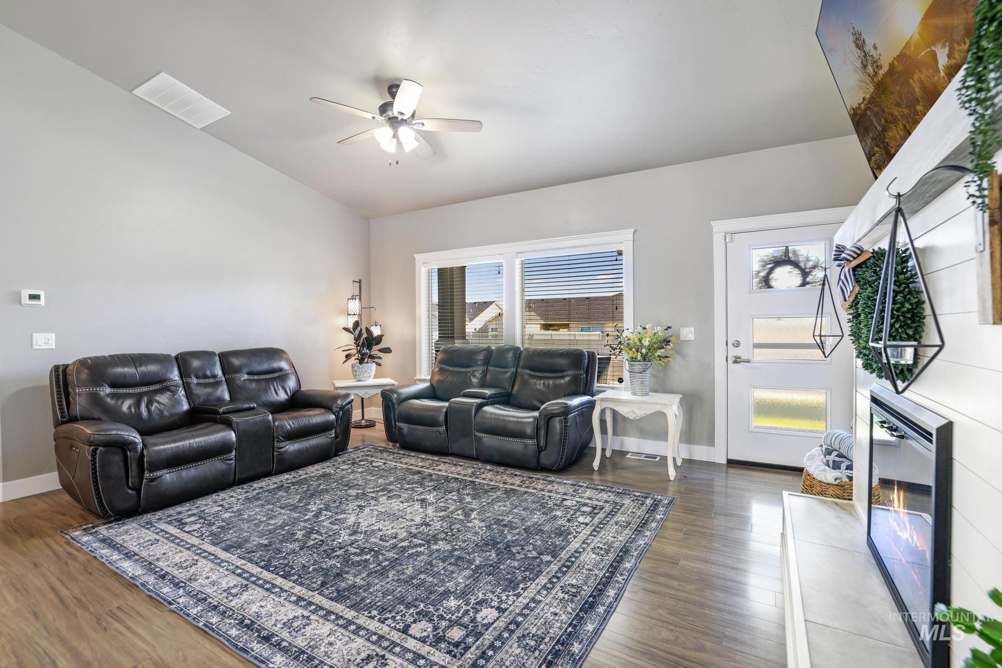 1050 Birchton Loop Twin Falls, ID 83301 - Photo 4 of 45 Spacious living area featuring wood-finish flooring, a contemporary ceiling fan, and large windows with horizontal blinds