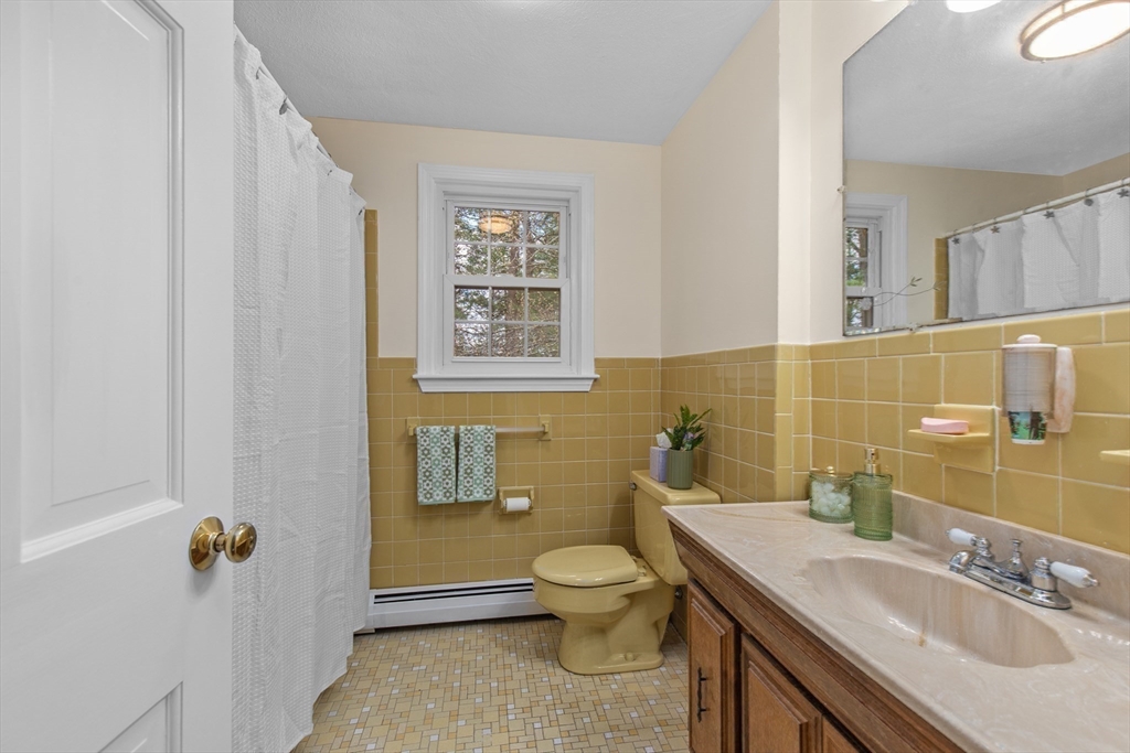 15 Massasoit Circle Walpole, MA 02032 - Photo 19 of 34 a bathroom with a granite countertop toilet a sink and a mirror