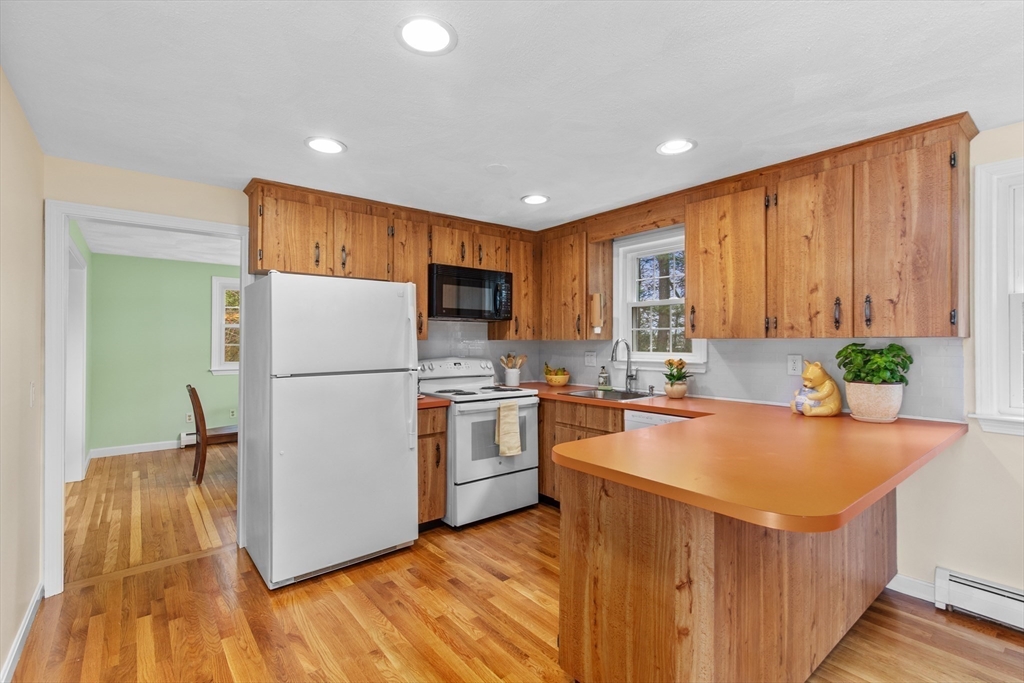 15 Massasoit Circle Walpole, MA 02032 - Photo 10 of 34 a kitchen with a refrigerator a stove top oven a counter space and wooden floor