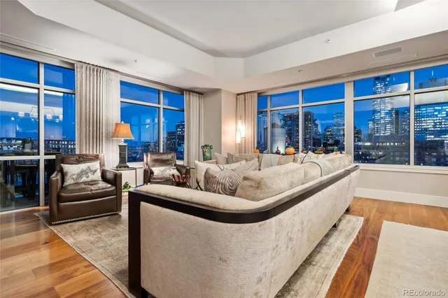 a dining room with wooden floor a chandelier a wooden table and chairs