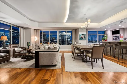 a living room with furniture kitchen view and a large window