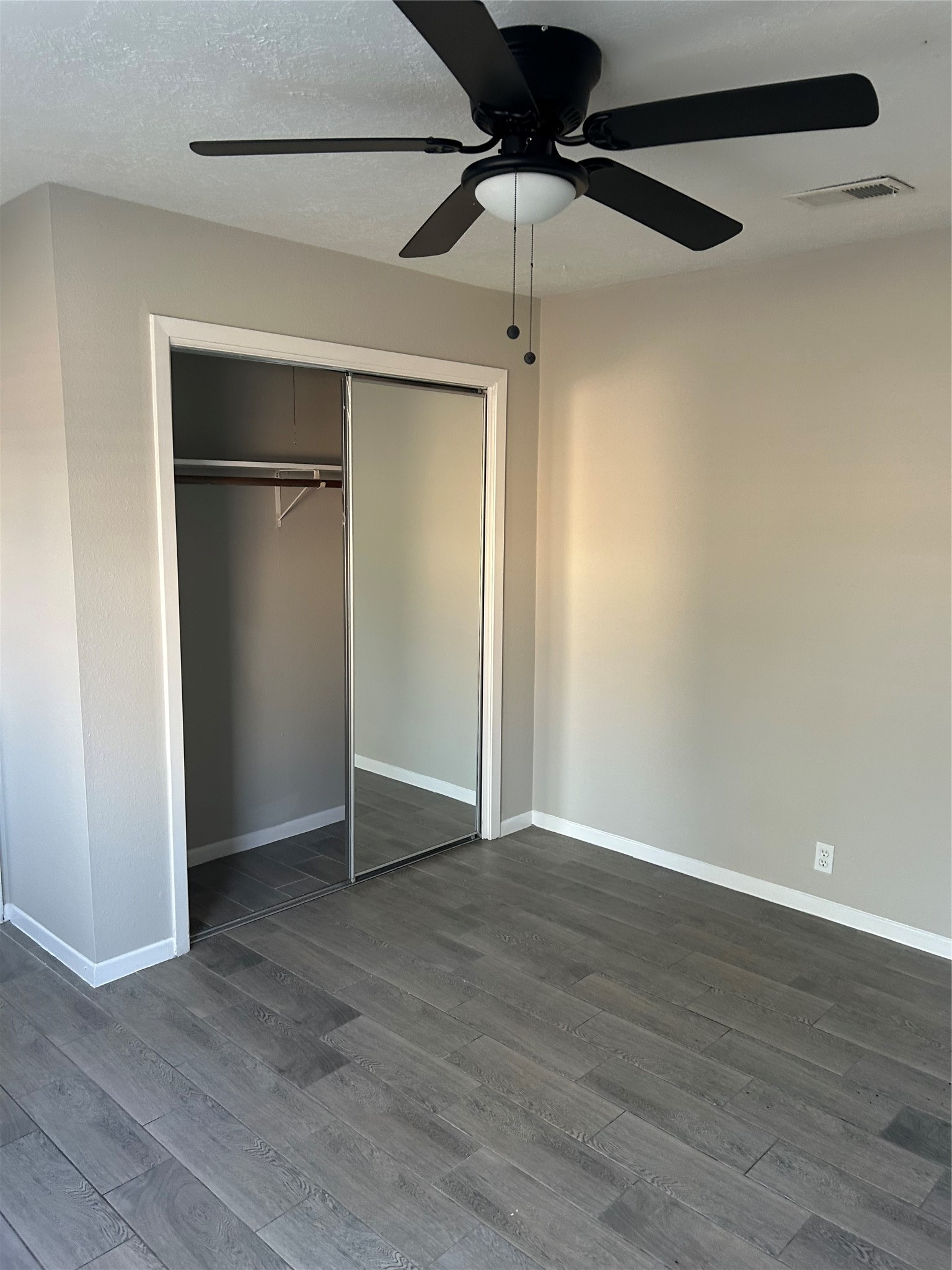 11719 Pender Lane Houston, TX 77477 - Photo 16 of 21 an empty room with wooden floor closet and ceiling fan