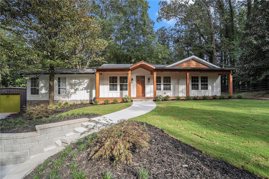 14855 Freemanville Road Milton, GA 30004 - Photo 1 of 1 a front view of a house with a yard table and chairs