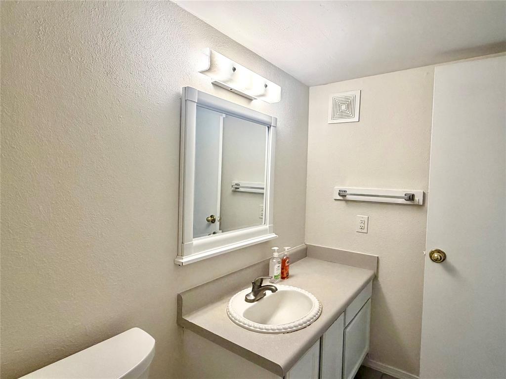 18333 Roehampton Drive, Unit 624 Dallas, TX 75252 - Photo 22 of 39 a bathroom with a sink toilet and mirror