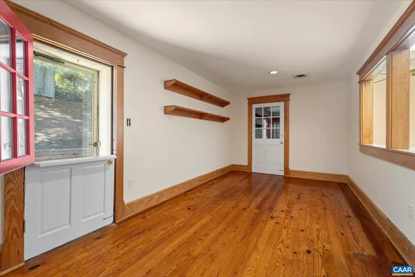 a view of empty room with wooden floor and fan