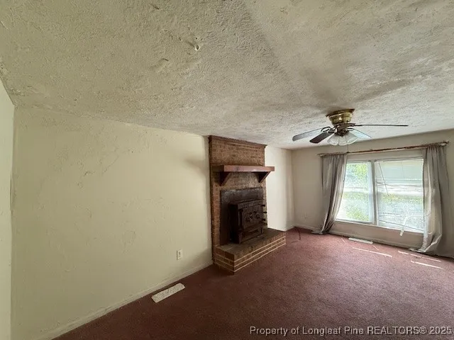 an empty room with windows and ceiling fan