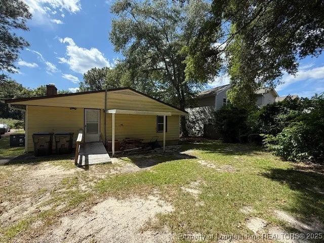 a view of a house with backyard and trees