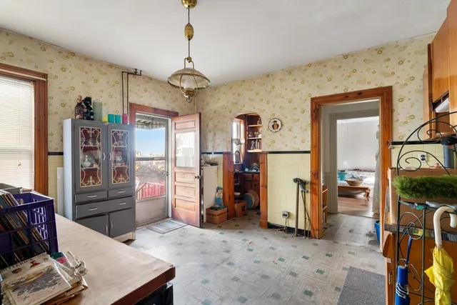 a living room with furniture a flat screen tv and a refrigerator